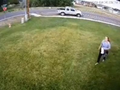 Person cutting across man's front lawn sprinkler