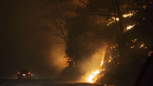 A car in Tennessee driving beside a wildfire. (AAP)