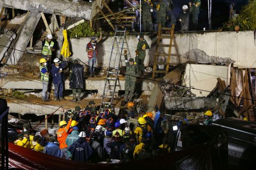 Rescue personnel work on the rescue of a supposedly trapped child at the collapsed Enrique Rebsamen primary schoool. (AP)