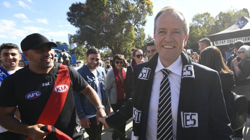 Bill Shorten speaks to a fan as he arrives to watch the ANZAC Day game between Essendon and Collingwood at the MCG.