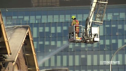 Fire crews brought in cranes to help battle the remnants of the blaze. (9NEWS)