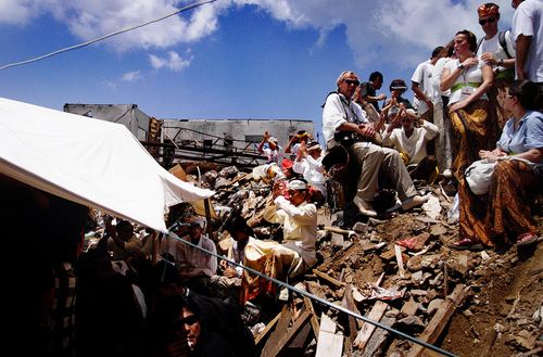 Families and friends of the Bali bombing sit amongst the rubble of where the Sari club once stood