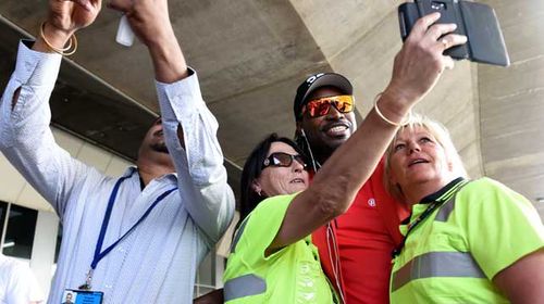 Chris Gayle poses for selfies with Melbourne airport staff yesterday. (AAP)