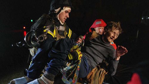Kiev'de Rus saldırısı sonrası yaralanan bir kadın ambulansa taşınıyor.