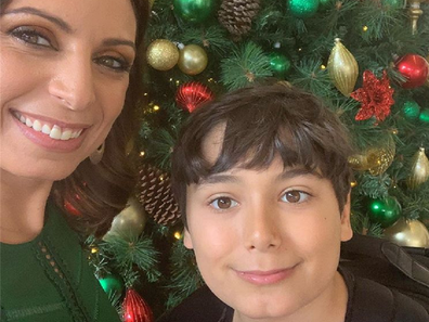 Jo Abi and her son standing in front of a Christmas tree