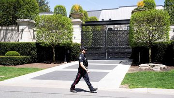 A Toronto police officer walking outside of Drake&#x27;s mansion in Toronto after a security guard was shot outside the home on Tuesday.