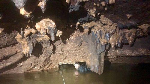 Senior Constable Justin Bateman tunnelling through the cave with the rope