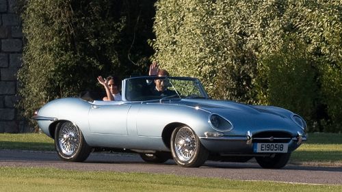 The newlyweds were snapped leaving Windsor Castle in a silver-blue Jaguar E-Type electric car followng a day of glitz and glamour. 