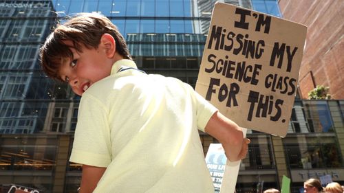 A young boy protests against climate change in Martin Place.