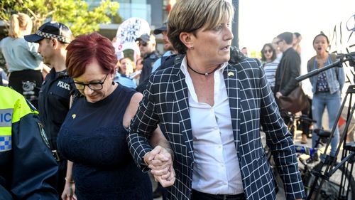 Christine Forster, Liberal councillor in the City of Sydney and sister of former prime minister Tony Abbott, is caught up in a crowd of protesters outside a fundraising event in Redfern, Sydney. (AAP)