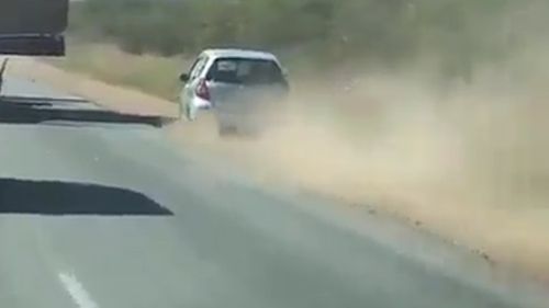 The small hatchback car veers off the road in an attempt to speed up and pass the truck. Picture: Facebook/Road Trains Australia.