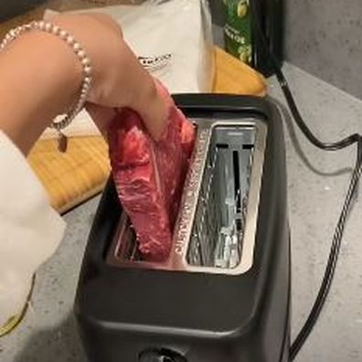 Woman cooks steak in a toaster