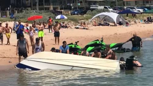 A group of bystanders leapt into action after the boat overturned. (9NEWS)