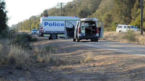Police vans block a road leading to the scene of the fatal shooting of an environment department worker on a property in Moree. 