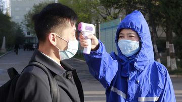 A man in Pyongyang, North Korea, gets his temperature checked as part of a coronavirus control measure.