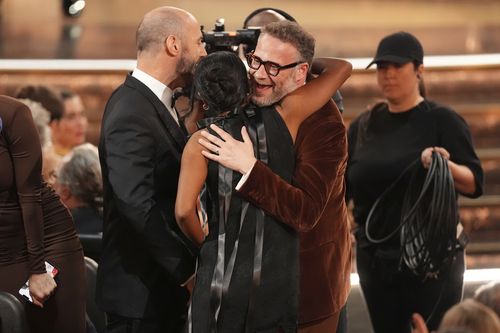 Evan Goldberg, da esquerda, Frida Perez e Seth Rogen abraçam depois de ganhar o prêmio por escritos excelentes para uma série de comédia para 