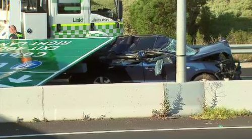 A woman has been taken to hospital after the overhead sign fell onto a car below.