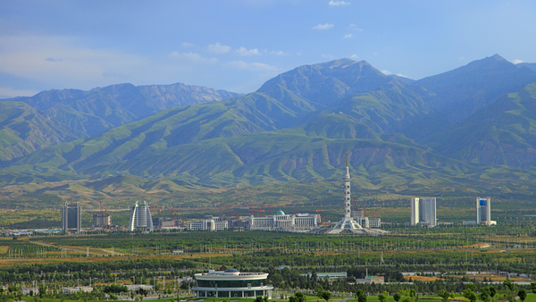 Ashgabat, Turkmenistan: Constitution monument and government buildings on Archabil avenue with mountains in the background