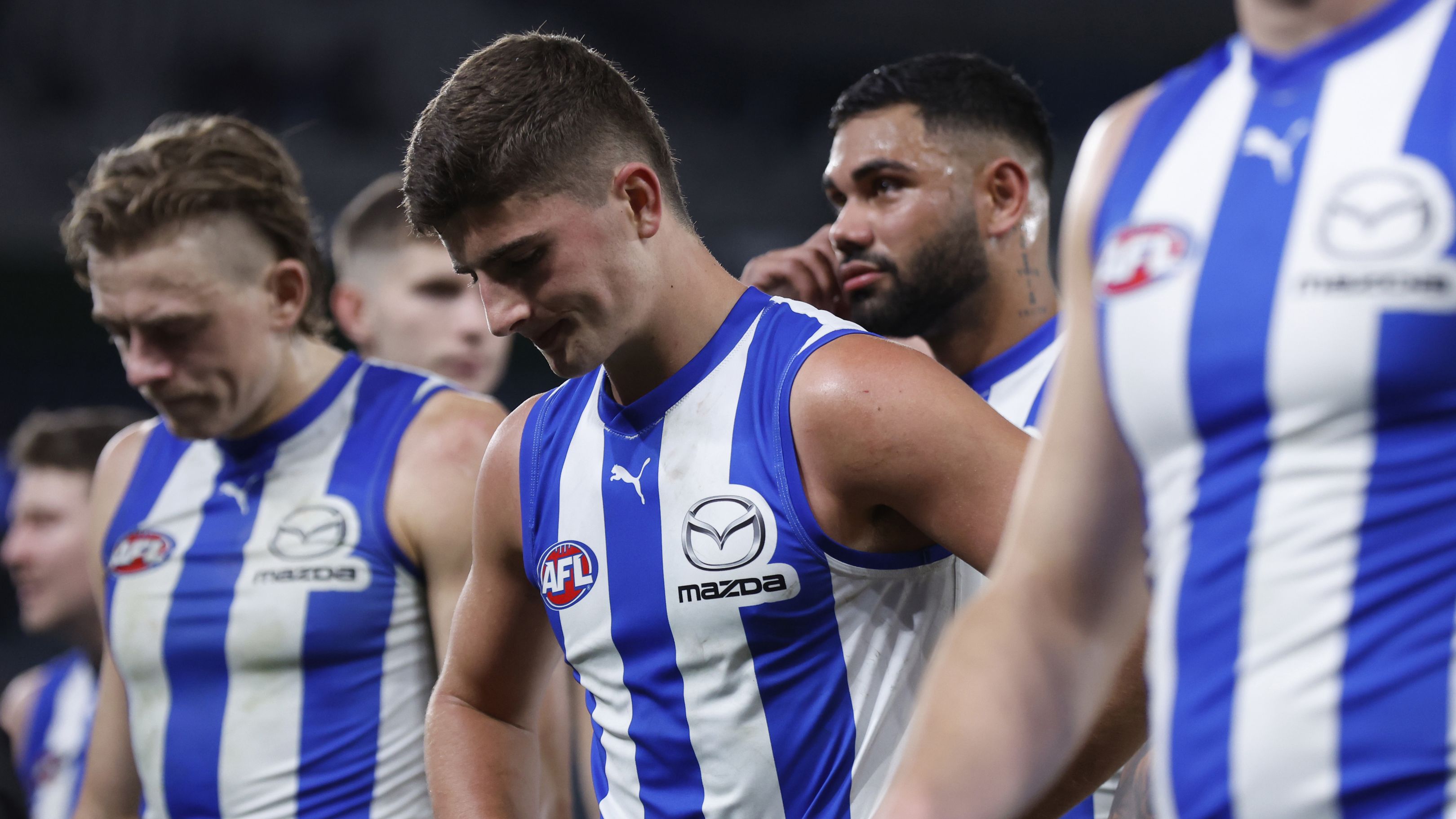 Dejected North Melbourne players walk from the ground after the round 14 AFL match between North Melbourne Kangaroos and Western Bulldogs.