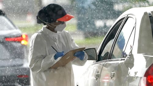 A healthcare worker takes down a patients information at a United Memorial Medical Centre COVID-19 testing site  in Houston, Texas.