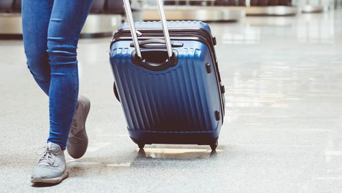 Woman in international airport walking with luggage