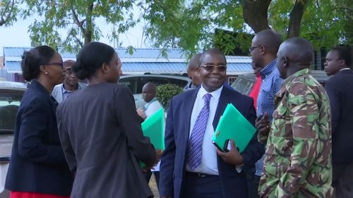 Mr Maina's lawyer, Wilfred Nderitu, talks to people leaving the court room.