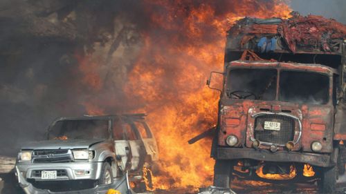 Vehicles burn at the scene of a massive explosion in front of Safari Hotel in Mogadishu, Somalia. (AAP)