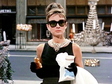 Audrey Hepburn wearing her little black dress, pearl jewelry and sunglasses in Breakfast at Tiffany's.