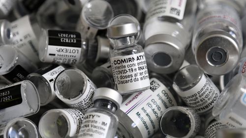 In this file photo dated Saturday, May 15, 2021, empty vials of the Pfizer-BioNTech COVID-19 vaccine lie in a box during a vaccine campaign in Ebersberg near Munich, Germany. (AP Photo/Matthias Schrader, FILE)