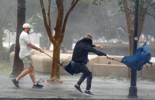 Des rafales de vent, soufflant sur King Street, tordent des parapluies lors de l'ouragan Ian à Charleston, en Caroline du Sud, le vendredi 30 septembre 2022 