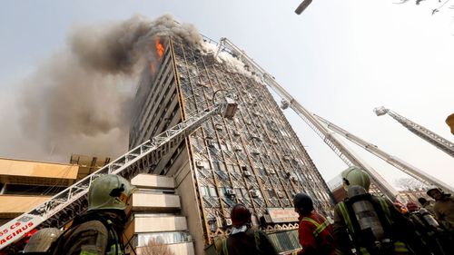 Crews struggle to contain a blaze in Tehran's oldest high-rise. (AFP)