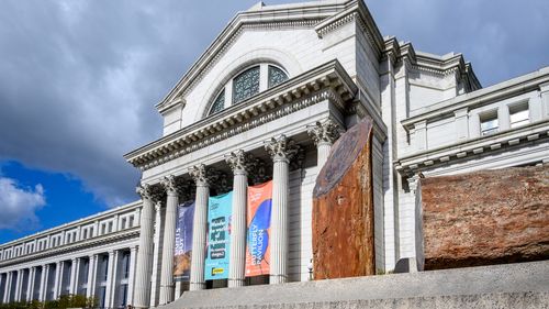 Washington, DC -26 de janeiro de 2024: O exterior do Museu de História Natural do Smithsonian Institution. Madeira petrificada está exposta em uma plataforma em frente ao museu.