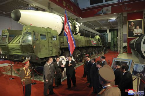 Kim Jong Un, centre, speaks in front of what the North says an intercontinental ballistic missile displayed at an exhibition of weapons systems.