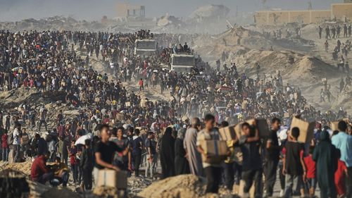 FILE - Palestinians carry sacks and boxes of food and humanitarian aid, unloaded from a World Food Program convoy that was heading to Gaza City in the northern Gaza Strip, Monday, June 16, 2025. (AP Photo/Jehad Alshrafi, file)