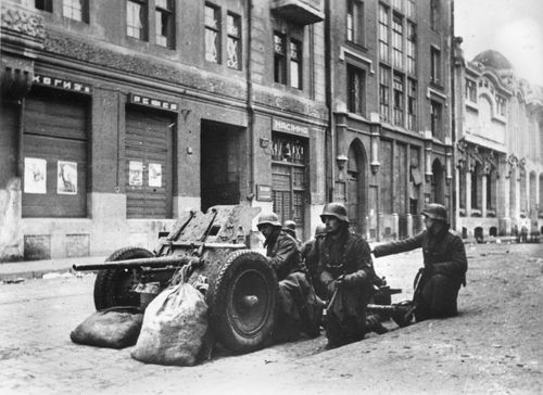 A German anti-tank artillery crew is shown in position in a street of the Russian industrial city Kharkov in the Ukraine during Nazi occupation, Dec. 15, 1941 during World War II.  War posters appear on the building at left.  (AP Photo)