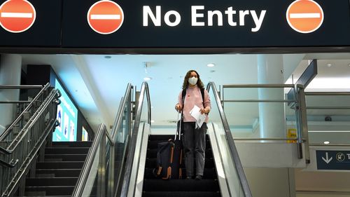 A woman arrives at the domestic terminal at Sydney airport off a Jetstar flight from Melbourne.