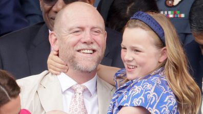 Mia Tindall gives dad Mike Tindall a hug as they watch the Platinum Jubilee Pageant outside Buckingham Palace in London, Sunday June 5, 2022.