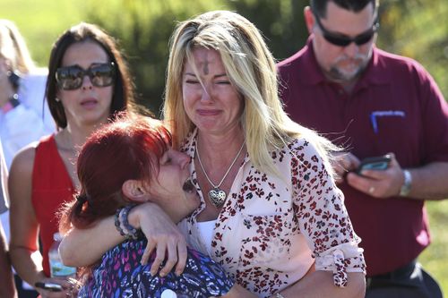 Heartbroken victims of the Florida shooting just photographed just hours after the tragedy. Picture: AAP