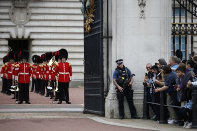 Members of the public wait outside Buckingham Palace to watch the Changing of the Guard ceremony on August 23, 2021 in London, England. The event marks the return of one of the city's top tourist attractions which had not been performed since March 2020. 