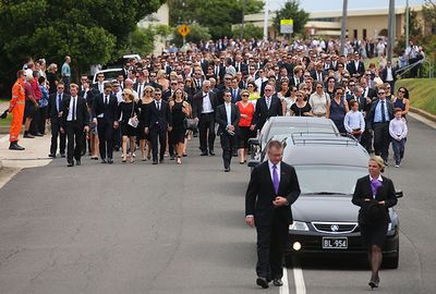 Mourners follow the hearse carrying Hughes' casket.