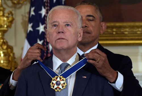 President Barack Obama presents Vice President Joe Biden with the Presidential Medal of Freedom during a ceremony in the State Dining Room of the White House in Washington. (AAP)