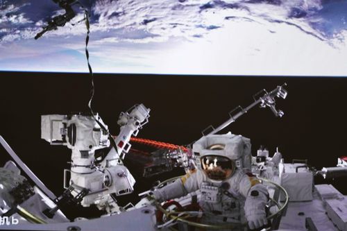 Chinese astronaut Cai Xuzhe exiting the station lab module Wentian to conduct extravehicular activities.