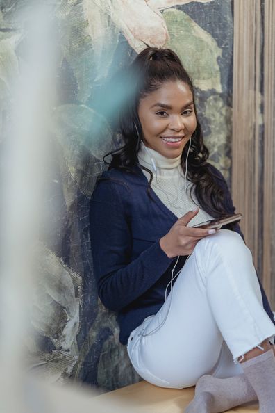 Woman with phone in her hand, sitting down