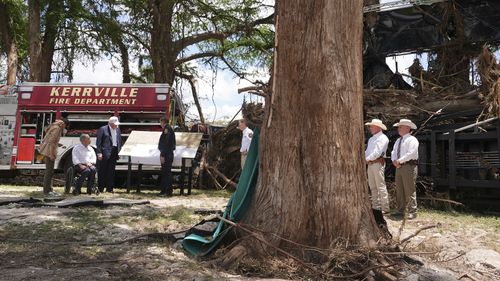 First lady Melania Trump, from left, Texas Gov. Greg Abbott and President Donald Trump are briefed on flood damage in Kerrville, Texas, Friday, July 11, 2025. (AP Photo/Jacquelyn Martin)