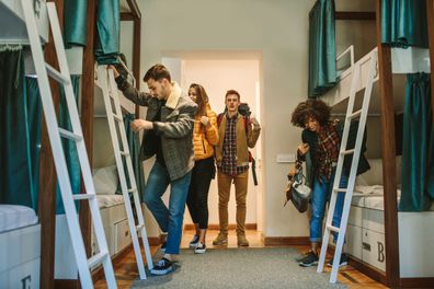 Young travelers in hostel bedroom.