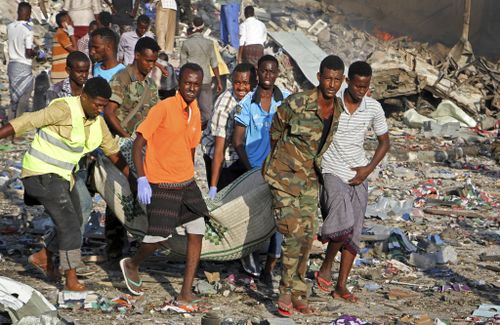 Somalis rescue a man from the rubble of the destroyed buildings. (AP)