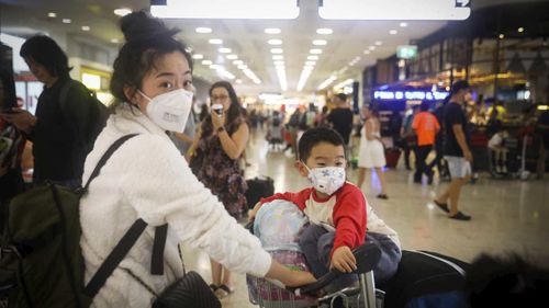 People arrive wearing masks to avoid contact with the Coronavirus at Sydney Airport.