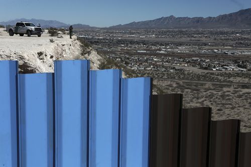 An US border patrol agent observes near the Mexico-US border fence, on the Mexican side, separating the towns of Anapra, Mexico and Sunland Park, New Mexico.