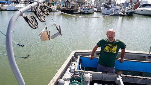 Salmon fisherman Mike Hudson stands at the back of his boat at the Berkeley Marina in California.