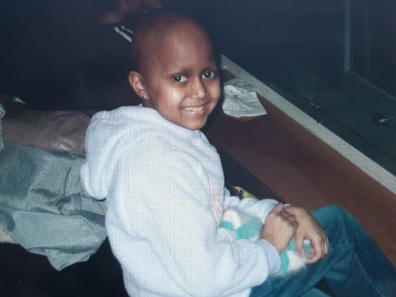 Lena Mishra as a child after losing her hair during brain cancer treatment.